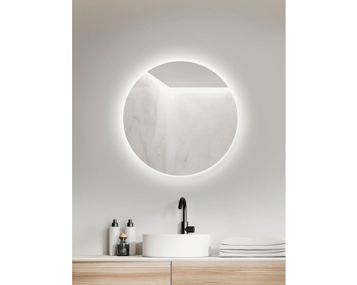 Salle de bains avec miroir rond, lavabo et robinetterie