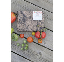 Boîte de graines avec différentes variétés de tomates et de semences sur fond en bois.