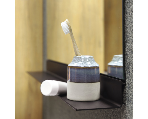 Scène de salle de bains avec gobelet à brosse à dents, brosse à dents et produit cosmétique sur une étagère