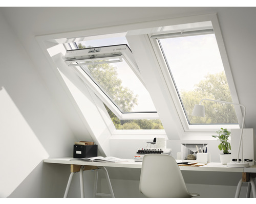 Deux fenêtres de toit dans un bureau lumineux avec un bureau