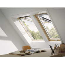 Zwei Dachfenster mit Holzrahmen in einem Dachzimmer mit Schreibtisch