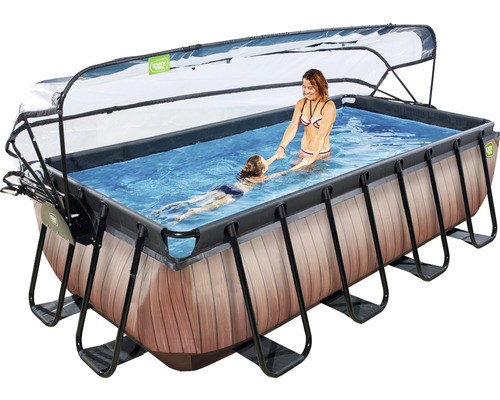 Piscine rectangulaire avec couverture, échelle et aspect bois, dans laquelle une femme aide un enfant à nager.