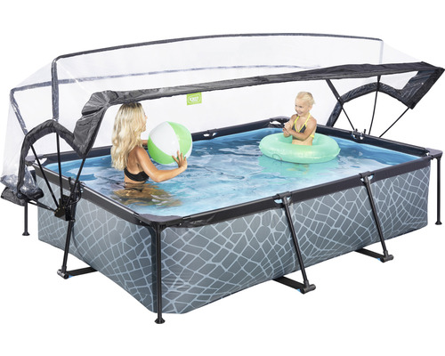Rechteckiger Pool mit Überdachung, gefüllt mit Wasser, in dem eine Frau mit einem Ball und ein Kind mit einem Schwimmreifen spielen