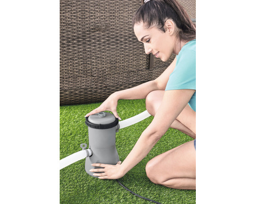 Femme installant un système de filtration de piscine sur une pelouse
