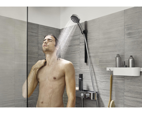 Homme sous une douchette dans une salle de bains moderne