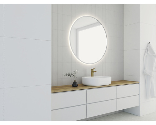 Salle de bain moderne avec miroir rond, lavabo et carrelage blanc