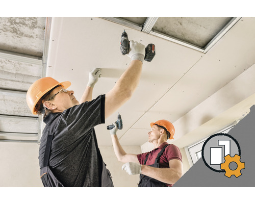 Zwei Arbeiter montieren eine Deckenverkleidung mit Gipskartonplatten.