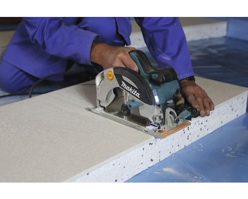 Eine Person schneidet eine Dämmplatte mit einer Makita Kreissäge.