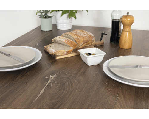 Table à manger avec pain, olives, assiettes et couverts