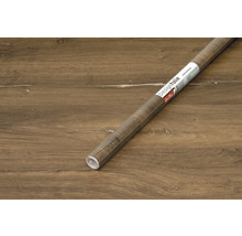 Rouleau de film décoratif aspect bois sur plancher en bois