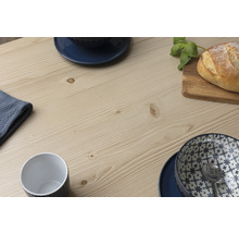 Detailansicht einer Tischplatte aus Holz mit Geschirr und Brot