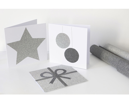 Dekorative Karten mit Stern, Kugeln und Geschenkbandmotiven sowie Geschenkpapierrollen.