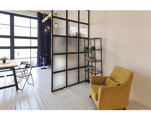 Pièce à vivre avec table à manger, chaises, séparation de pièce, étagère et fauteuil.