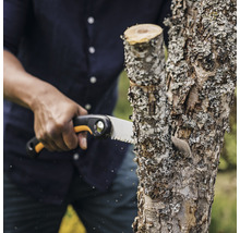 Personne scie une branche avec une scie à main