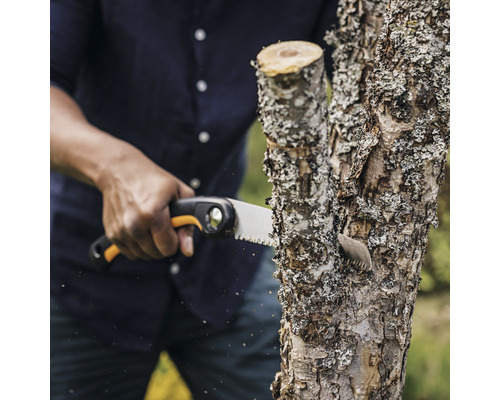 Personne scie une branche avec une scie à main