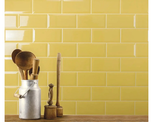 Wandfliesen mit Holzlöffeln in Milchkanne