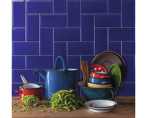 Dekorative Küchenszene mit blauen Fliesen, Kochgeschirr und Erbsen