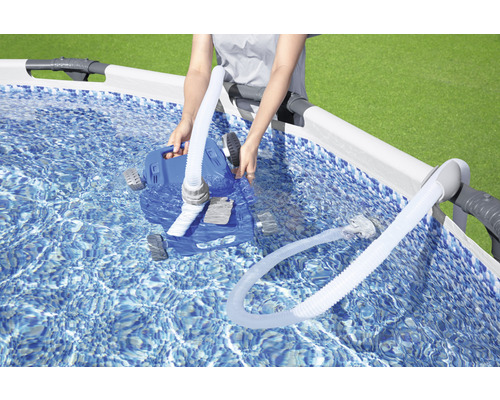 Une personne place un robot nettoyeur de piscine automatique dans une piscine