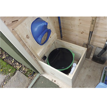 Vue intérieure d''une cabane en bois avec toilettes sèches et outils de jardinage