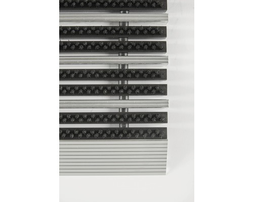 Vue détaillée d''un tapis de sol avec des brosses et des profilés en aluminium.