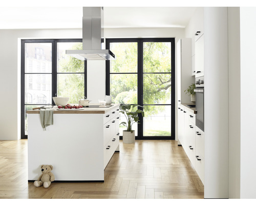 Cuisine claire avec îlot de cuisson, hotte aspirante et grandes fenêtres