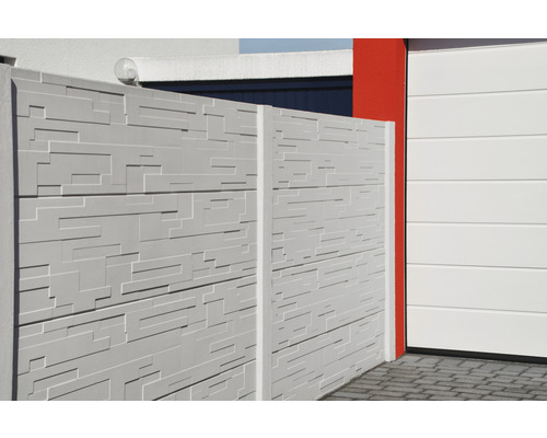 Clôture en béton avec motif structuré à côté d''un garage