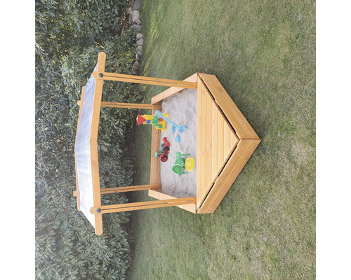 Bac à sable en bois avec jouets dans le jardin