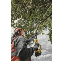 Un homme utilise une tronçonneuse d''élagage sans fil pour tailler des branches.