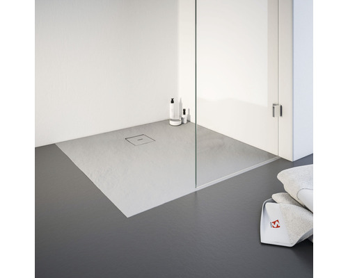 Douche à l''italienne avec caniveau de douche et serviettes de toilette dans la salle de bain.