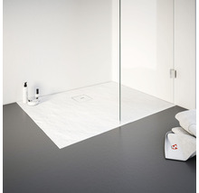 Douche de plain-pied avec receveur en grès et paroi de douche en verre dans une salle de bains lumineuse.
