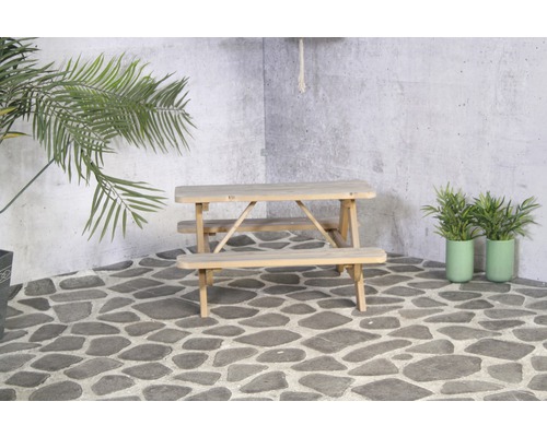 Table de pique-nique en bois avec des plantes dans le jardin