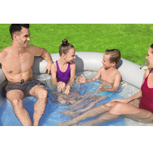 Familie entspannt in einem aufblasbaren Whirlpool im Garten.