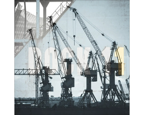 Plusieurs grues de construction devant un bâtiment