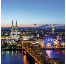 Vue nocturne de Cologne avec la cathédrale, le pont et les bâtiments illuminés.