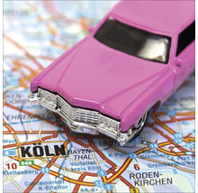 Rosa Spielzeugauto auf einer Strassenkarte von Köln