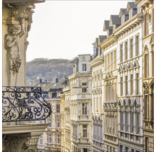 Ansicht einer Straße mit Gebäuden und einem verzierten Balkon