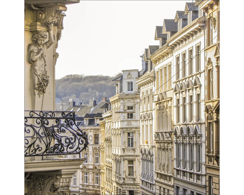 Ansicht einer Straße mit Gebäuden und einem verzierten Balkon