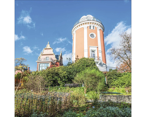Turm und Gebäude in einem Garten mit Pflanzen und Büschen