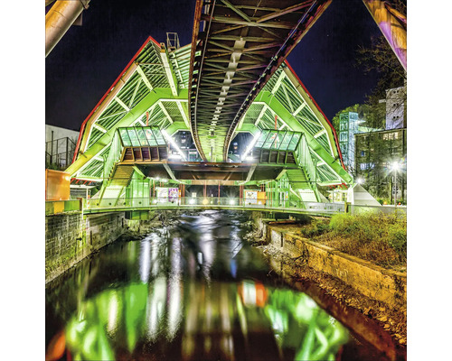 Station de monorail suspendu illuminée au-dessus d''une rivière dans un environnement urbain