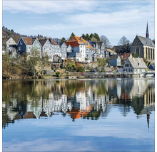 Vue d''une ville au bord d''un lac avec des reflets dans l''eau.