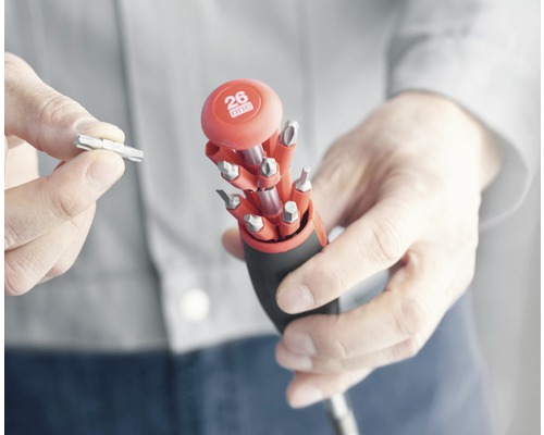 Tournevis multiple avec différents embouts tenu par une personne