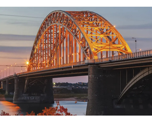 Ansicht einer beleuchteten Bogenbrücke bei Dämmerung.