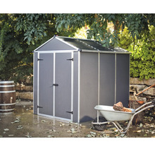 Abri de jardin métallique à l''extérieur avec brouette et bois