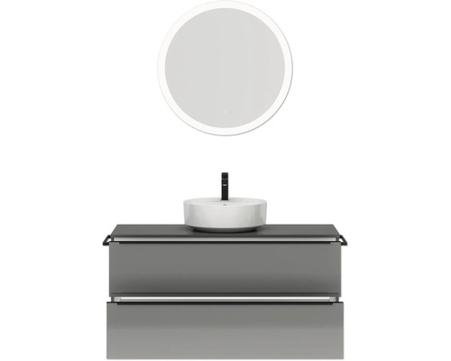 Badezimmer mit Waschbecken, Unterschrank und rundem Spiegel mit Beleuchtung