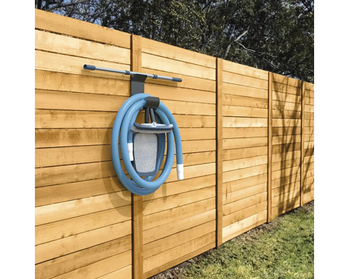 Poolreinigungsset mit Schlauch und Halterung an einem Holzzaun