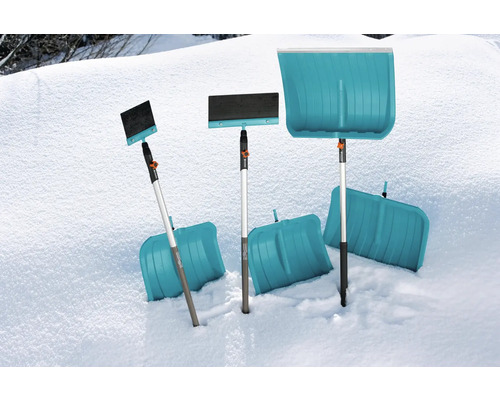 Diverses pelles à neige et balais à neige dans la neige