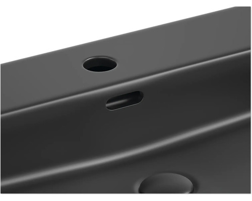 Detailansicht eines Waschbeckens mit Hahnloch und Überlauf