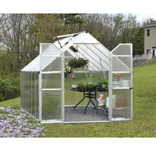 Serre avec des plantes sur une table dans le jardin.