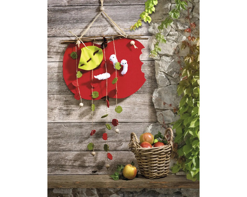 Décoration avec motif de pomme en feutre et laine de bois à côté d''un panier de pommes