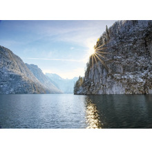 Paysage hivernal avec lac, montagnes et soleil